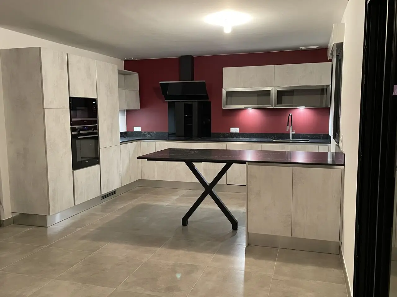 Cuisine contemporaine en îlot avec mur d'accent rouge et façades claires