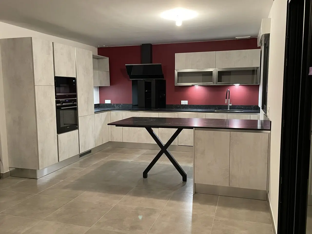 Cuisine contemporaine avec îlot et mur d'accent rouge